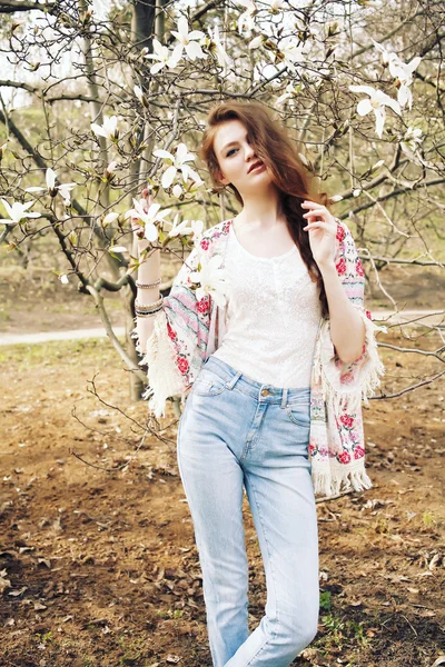 Genç güzel kadın çiçek açan Manolya bahçede poz model. — Stok fotoğraf