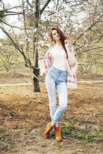 Fiatal gyönyörű modell nő a kertben, a virágzó magnóliák pózol. — Stock Fotó