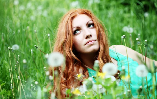 Портрет молодой весенней модницы, дующей одуванчик в весеннем саду . — стоковое фото