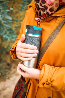 Elinde kahve tutan bir kadın.