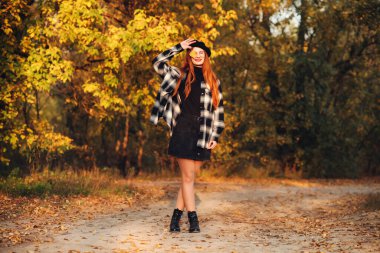 Parkta sırt çantalı sarı ceketli güzel bir kız.