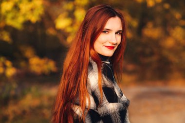 Güz parkında güzel bir genç kadın.