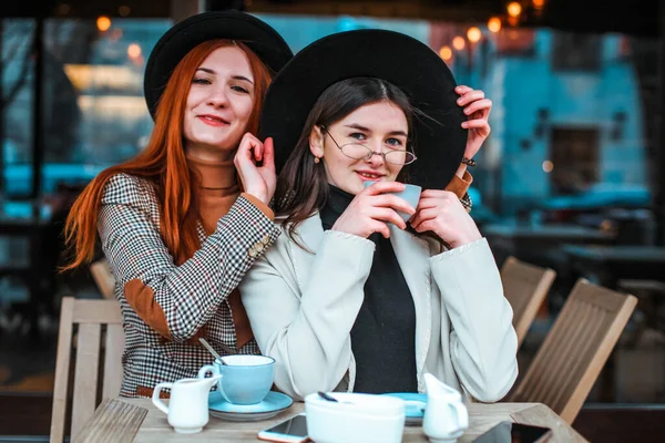 Two girl friends drinking coffee in the cafe