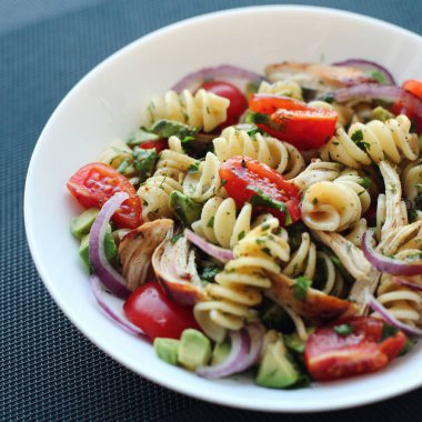 Domates, avokado, chiken ve kırmızı soğanlı makarna salatası.