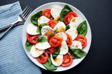 Domates, fesleğen, mozzarella Caprese salatası ve balzamik sirke.