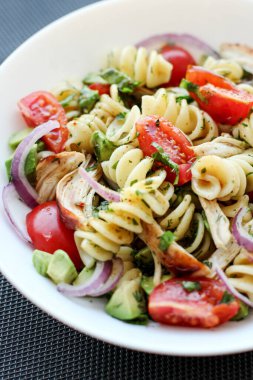 Domates, avokado, chiken ve kırmızı soğanlı makarna salatası.