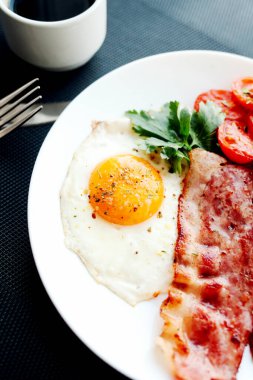 İngiliz kahvaltısı - kızarmış yumurta, domates, pastırma ve kraker