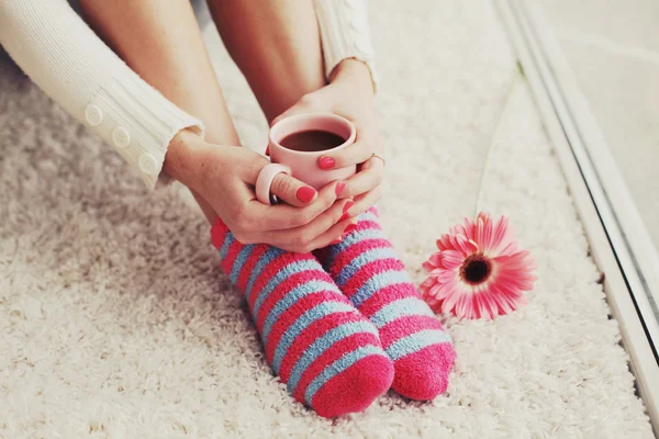 Женские ноги в носках и кофе — стоковое фото