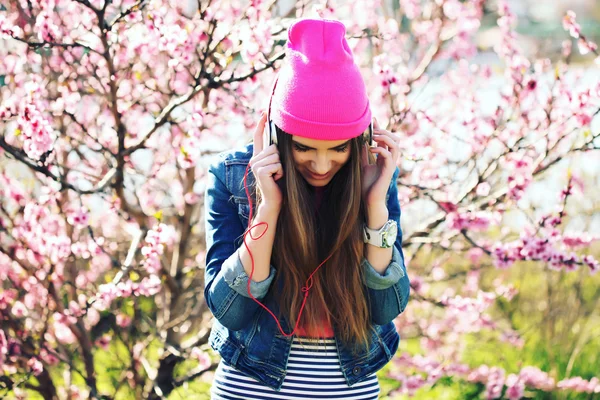 Gros plan portrait d'une jeune fille swag drôle sur jardin luxuriant écouter de la musique dans les écouteurs du lecteur mp3 téléphone intelligent . — Photo