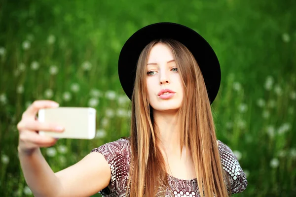 Hermosa chica con sombrero riendo por una selfie — Foto de Stock