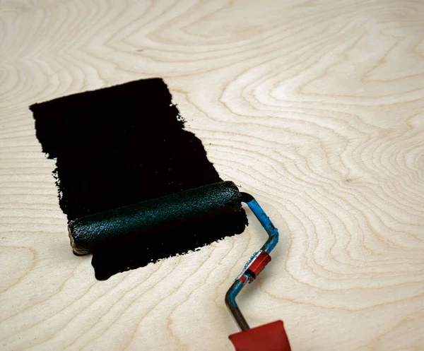 木制胶合板上漆成黑色的滚子 — 图库照片