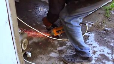 Açı öğütücü metali kesiyor, endüstriyel ortamda kıvılcımlar patlıyor. Ağır işçilik ve inşaat işleri. Tam HD.