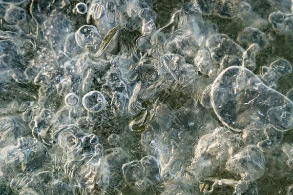 Ice texture with frozen air bubbles on the river. Ice background.