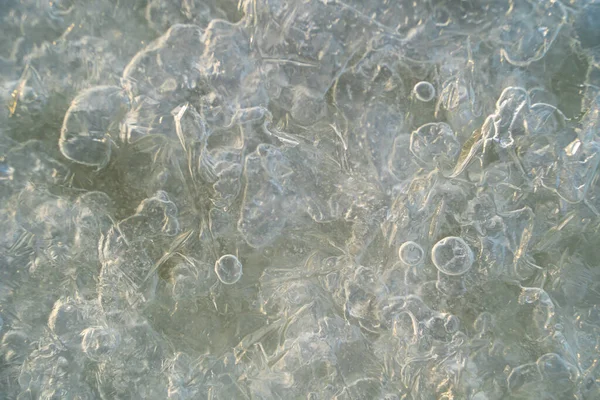 Ice texture with frozen air bubbles on the river. Ice background.
