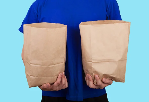 Hombre Con Una Camiseta Azul Sostiene Dos Bolsas Papel Con —  Fotos de Stock