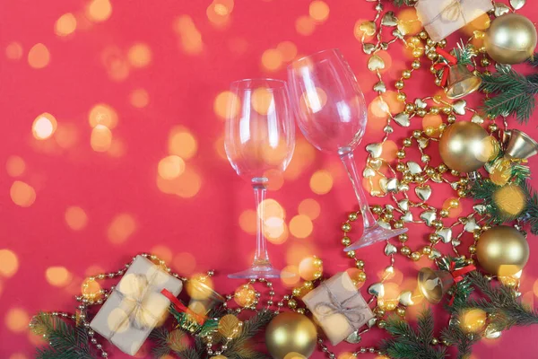 Weihnachtsschmuck Aus Christbaumzweigen Perlen Kugeln Und Sektgläsern Auf Rotem Grund — Stockfoto