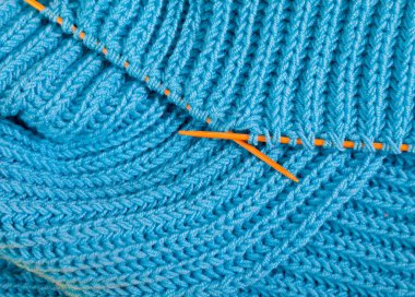 El yapımı mavi eşarp birkaç kez katlanmış.