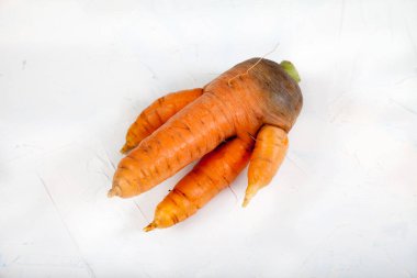 Beyaz arka planda kocaman çirkin bir havuç yatıyor.