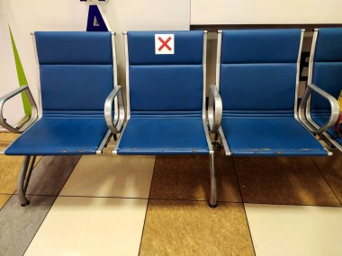 Sosyal uzaklık kavramı, havaalanı koltukları koronavirüs yüzünden uyarı levhası. COVID-19. Korona virüsü salgını ve salgını sırasında dikkatli olun. Mobil Fotoğraf