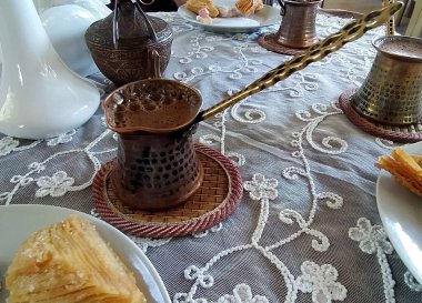 Coffee in a small turk on a stand and sweets in a cafe. National Crimean Tatar cuisine clipart