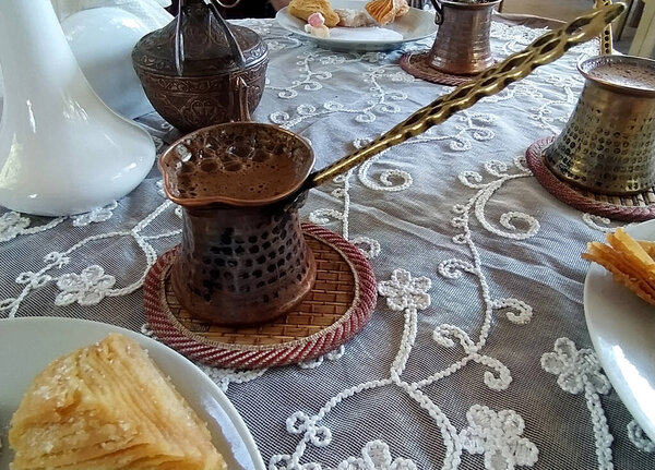 Coffee in a small turk on a stand and sweets in a cafe. National Crimean Tatar cuisine