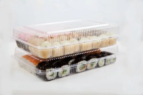 Dwa Zestawy Sushi Plastikowych Pojemnikach Białym Talerzu Dostawa Rolki — Zdjęcie stockowe