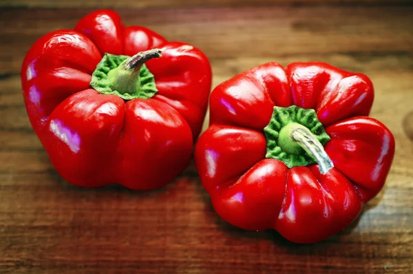 Two sweet red peppers on a wooden boards background — Stock Photo, Image