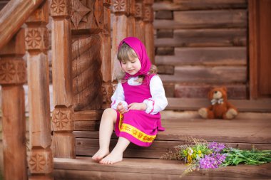 Petite Rus güzellik ahşap bir verandada oturuyor