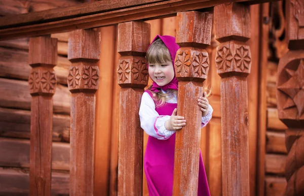 Pretty smiling girl playing on the carved wooden porch — Stock Photo, Image