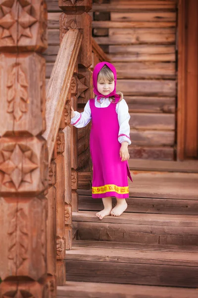 Slavic little girl standing barefoot on a wooden porch — Stock Photo, Image