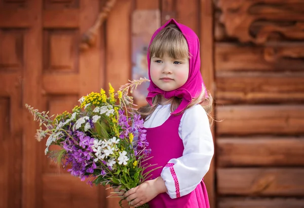 Slavic little girl in folk costume with a bouquet of wildflowers — Stock Photo, Image