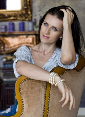 Kız onun koltuğunda yaslanmış oturuyor.