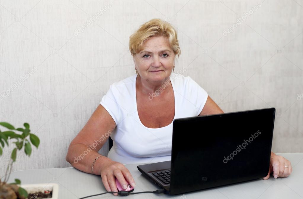 An elderly woman at the computer