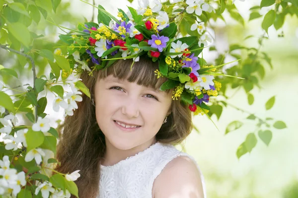 Girl with a wreath on the head of a blossoming Apple tree — Stock Photo, Image