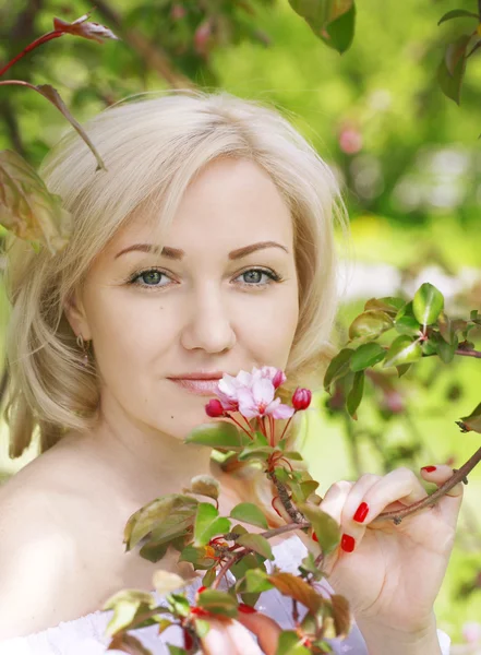 Girl holding blossoming branch of an apple tree — Stock Photo, Image