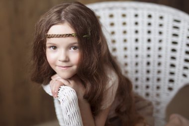 Geri sandalyede oturan kız eğildi