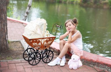 Girl sitting in prams for dolls