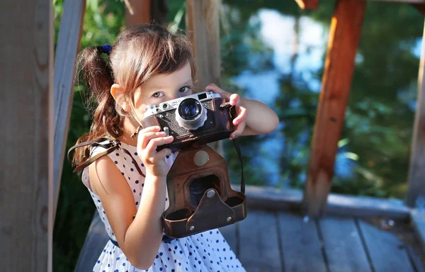 Girl trying to take a picture with a film camera — Stock Photo, Image