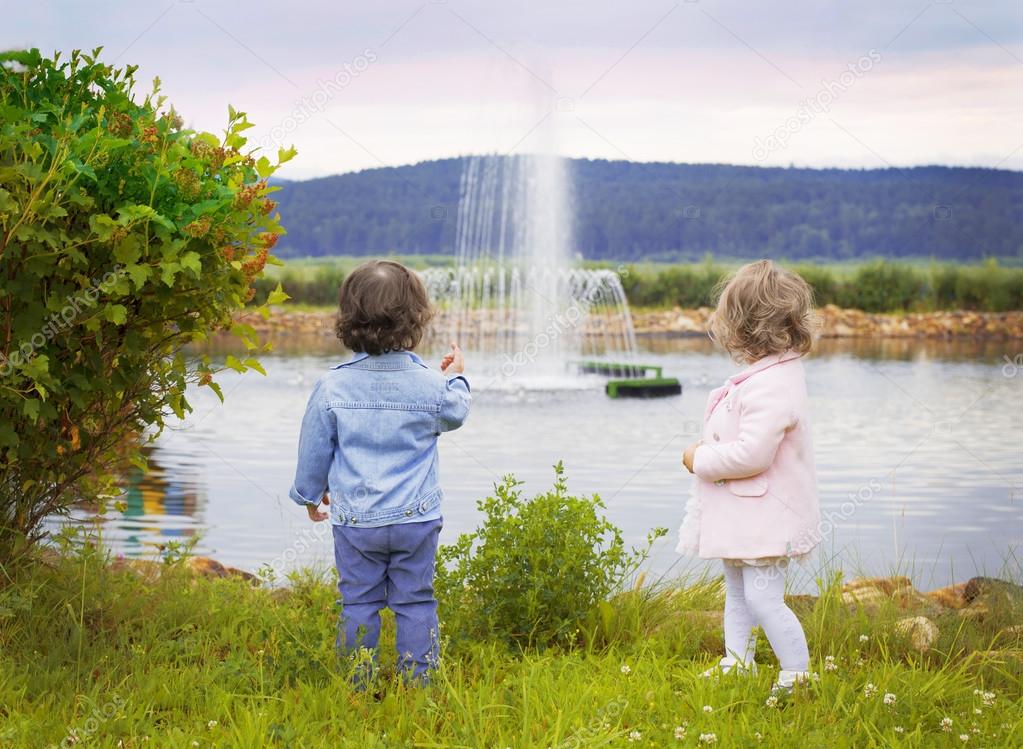 Little boy and girl look at the fountain