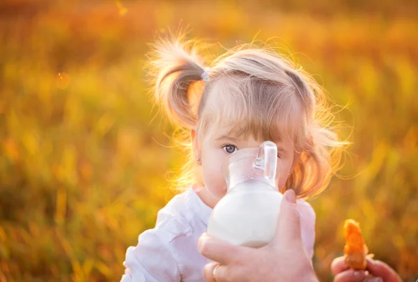 Lilla flickan dricka från en mjölkkanna — Stockfoto