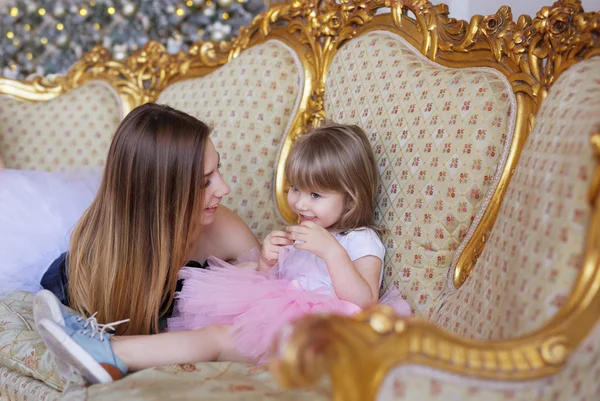 La ragazza con un bambino sul divano di lusso — Foto Stock