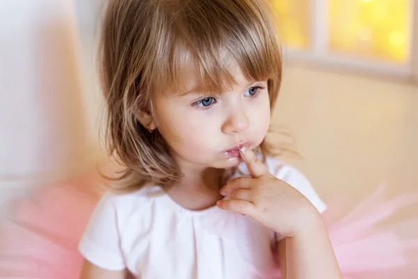 Girl holding finger in mouth — Stock Photo, Image
