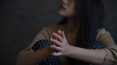 Stresli bir kadının elini kaldırdığı yavaş bir görüntü. Denenmiş ve üzgün bir şekilde, ahşap taburede oturan negatif bir duyguyla kafasına dokunuyor.