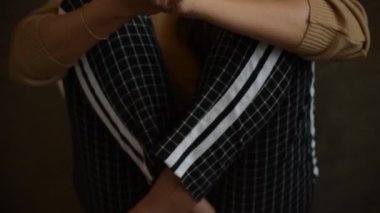Stresli bir kadının elini kaldırdığı yavaş bir görüntü. Denenmiş ve üzgün bir şekilde, ahşap taburede oturan negatif bir duyguyla kafasına dokunuyor.