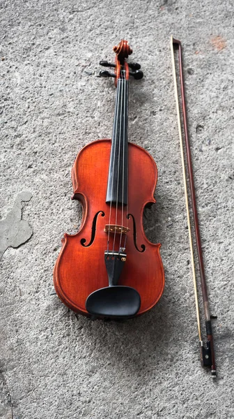 将小提琴和弓放在磨擦表面水泥底楼 展示音响仪器的细节 — 图库照片