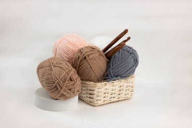 İplik topları ve örgü kancaları örülmüş sepete, bulanık aydınlığa konur.