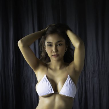 Küçük sutyen takan güzel bir bayan, elini kaldır saçına dokun, portre modeli pozu ver, seksi kadın.