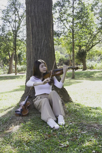 若い美しい女性が幸せな気持ちでバイオリンを弾いています 休日のための趣味 リラックスした時間 公園で — ストック写真