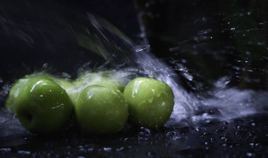 Sudan ıslanmış yeşil elmalar sıçrama, bulanık ışık