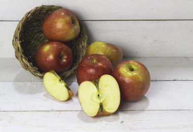 Elma ahşap tahtaya konur, bulanık ışık yayılır.